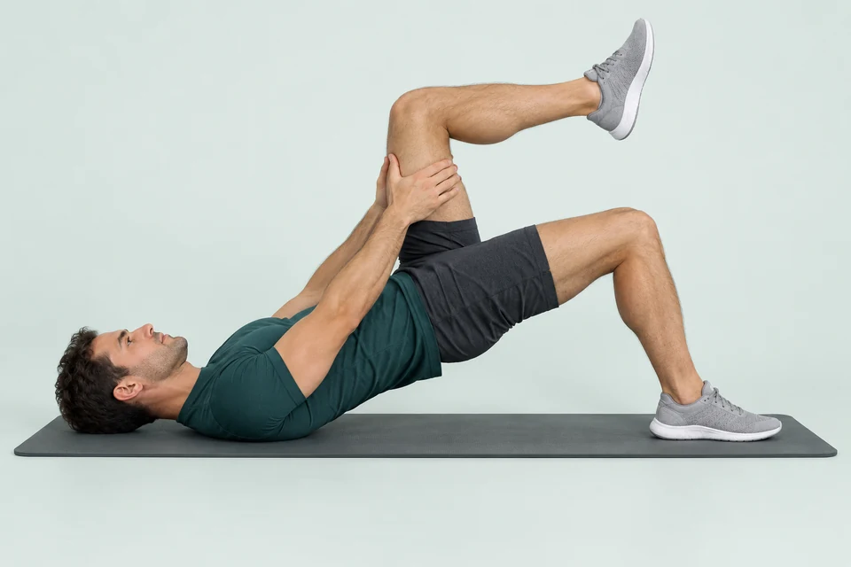 Single-leg bridge with one foot planted, level hips raised and the other thigh held with its hip and knee bent.